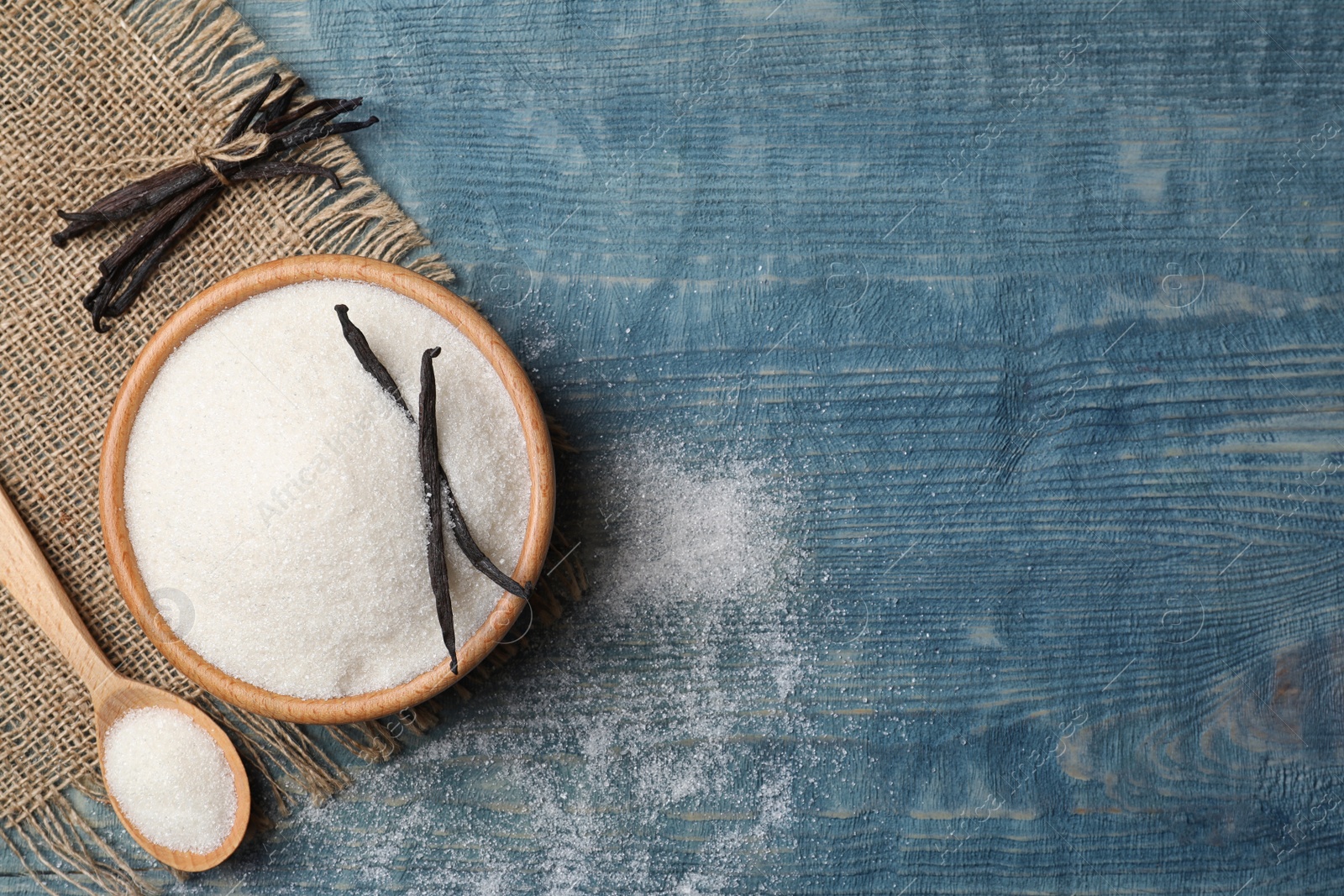 Photo of Flat lay composition with vanilla sugar on wooden background, top view