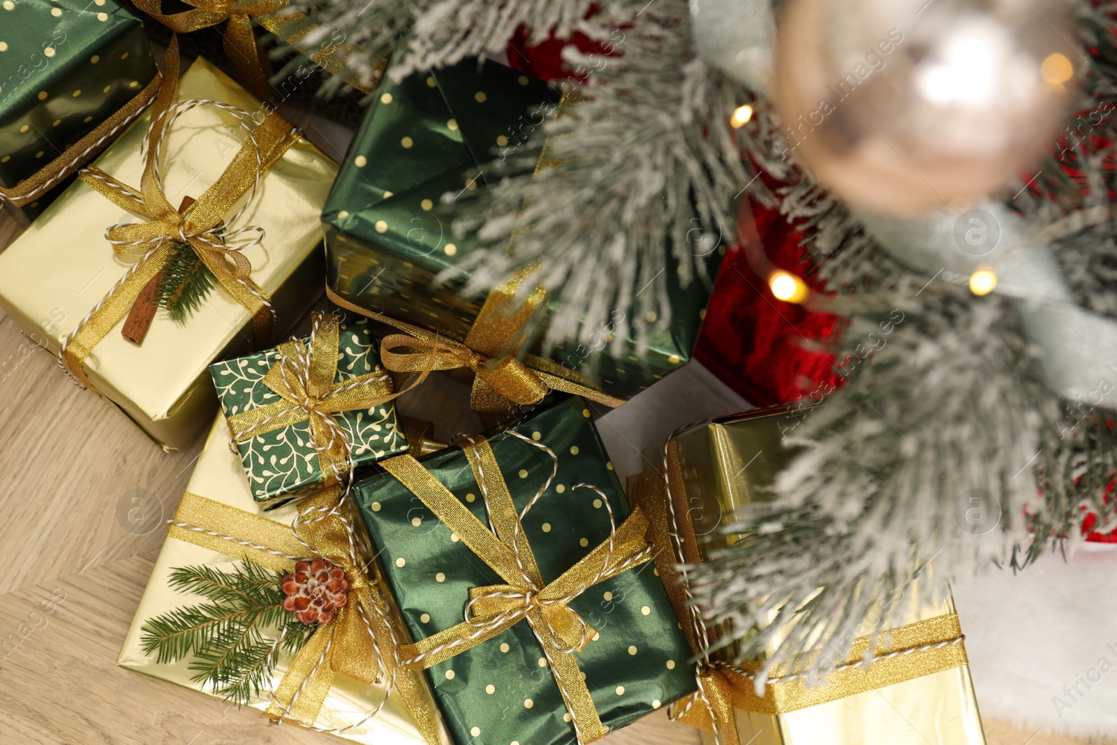 Photo of Many different gifts under Christmas tree indoors, top view