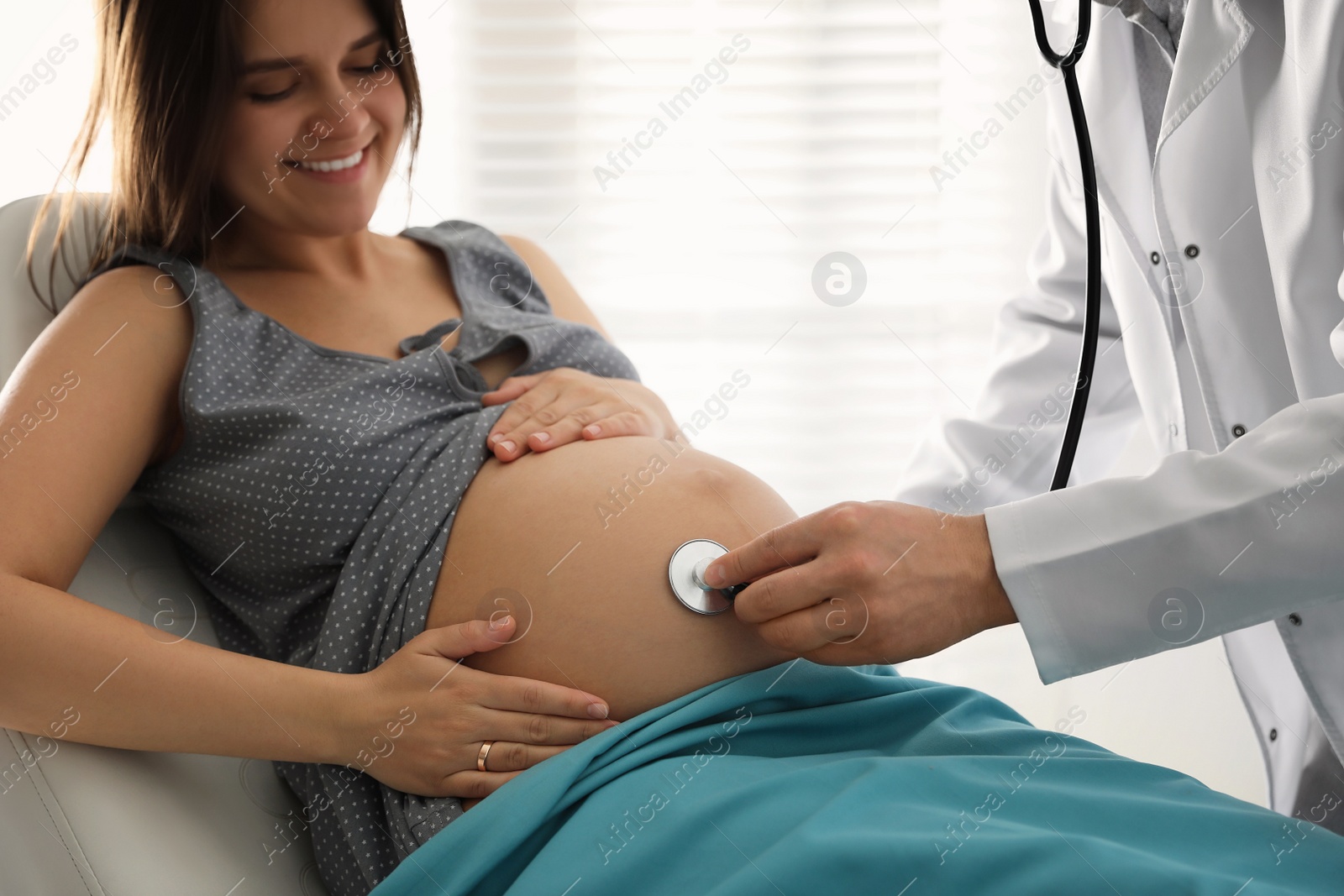 Photo of Doctor examining woman before giving child birth in maternity hospital, closeup