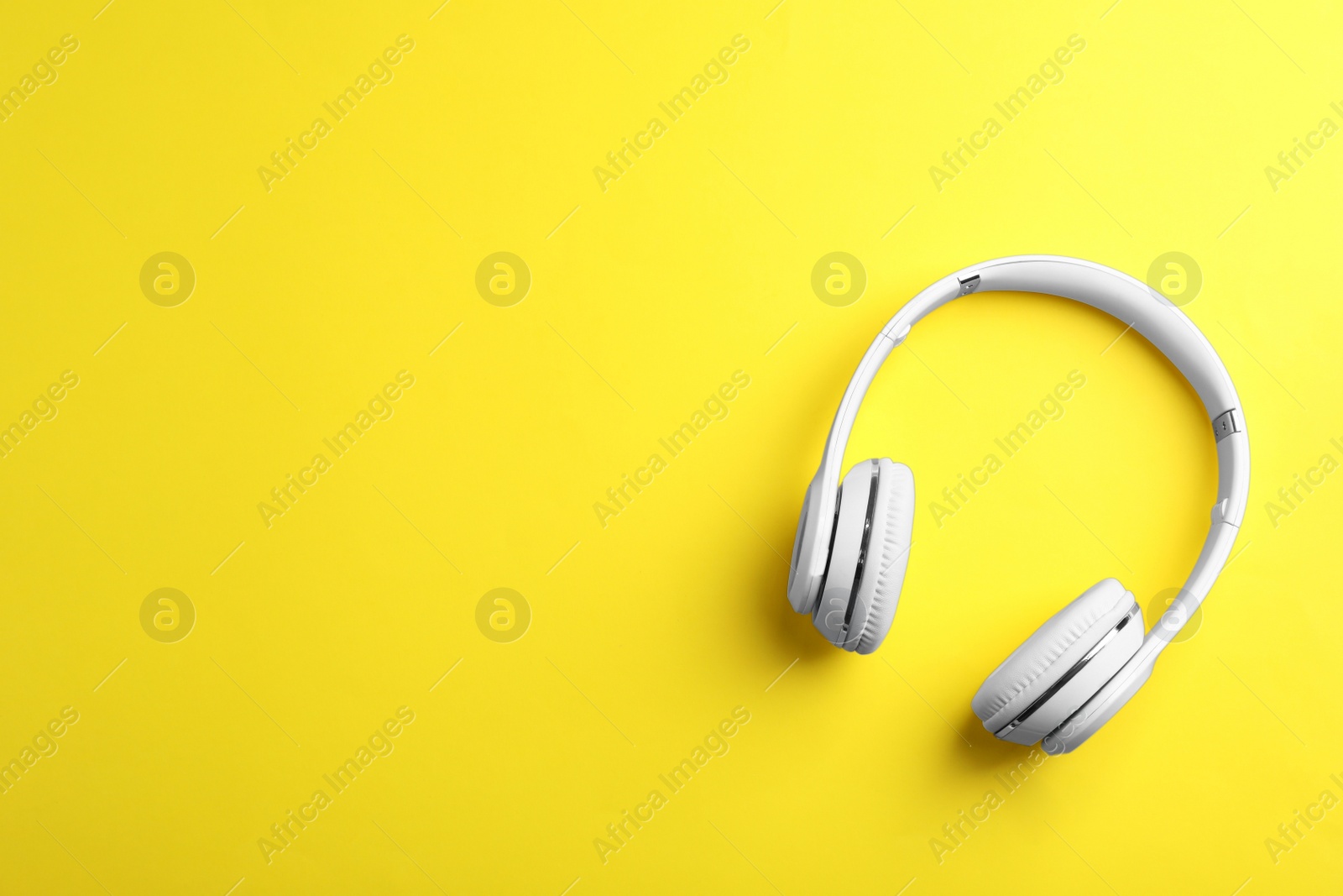 Photo of Wireless headphones on color background, top view. Space for text