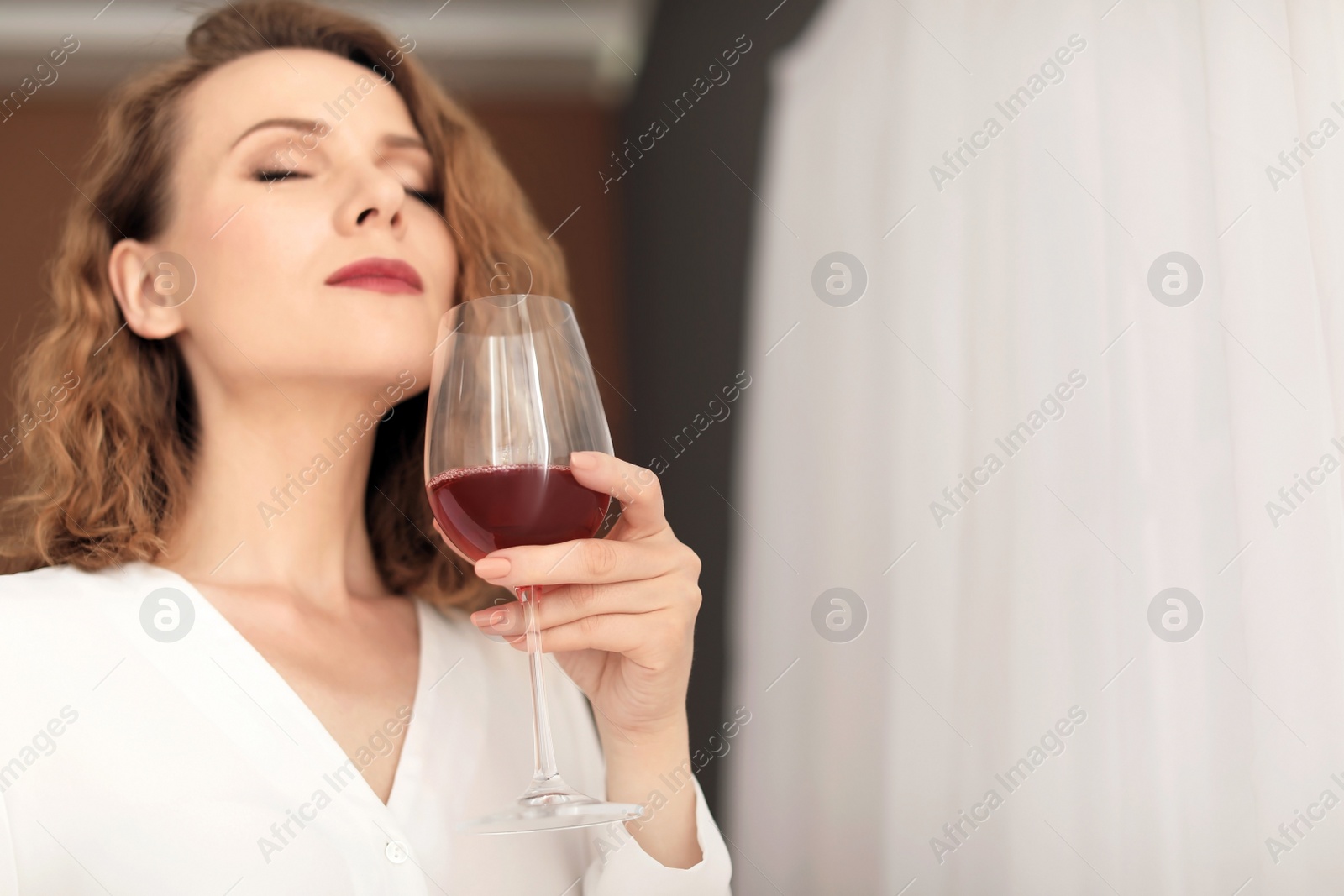 Photo of Woman with glass of delicious wine indoors