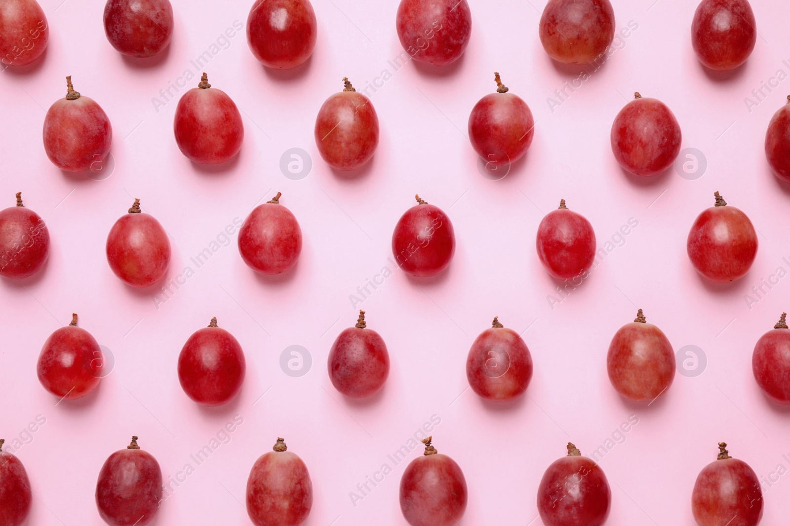 Photo of Flat lay composition with fresh ripe grapes on pink background