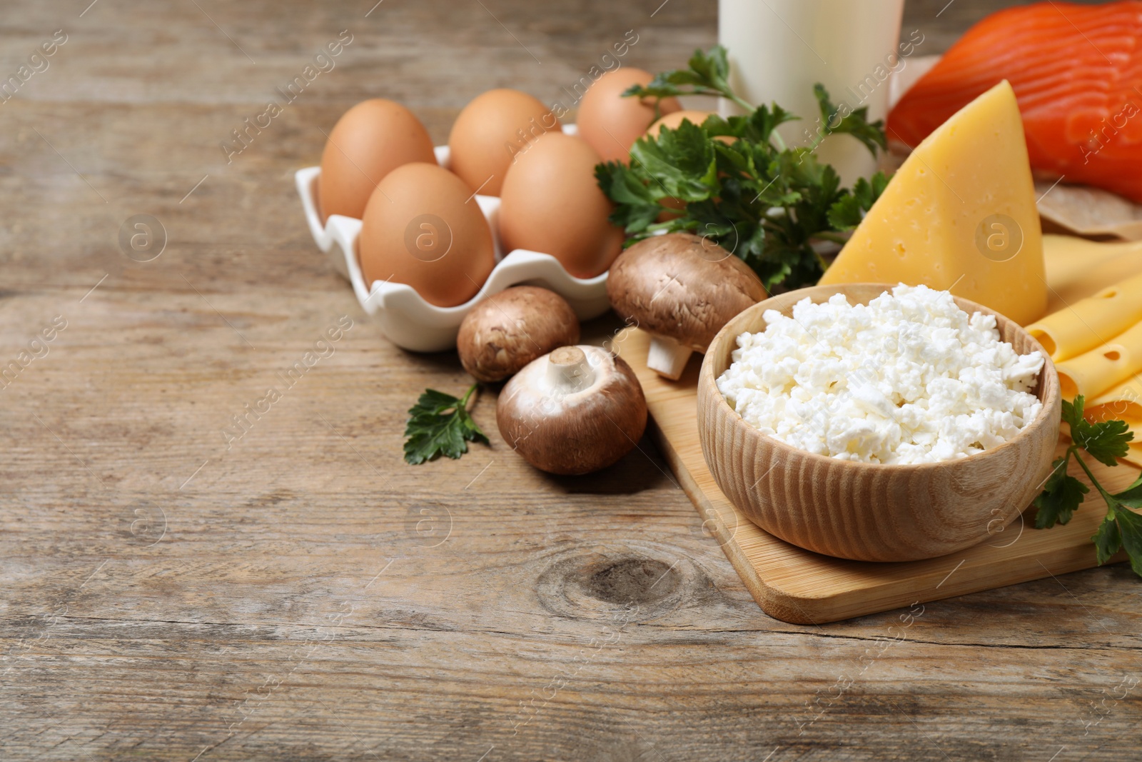 Photo of Fresh products rich in vitamin D on wooden table. Space for text