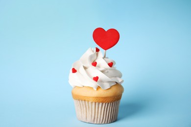 Photo of Tasty cupcake for Valentine's Day on light blue background
