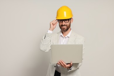 Photo of Professional engineer in hard hat with laptop on white background