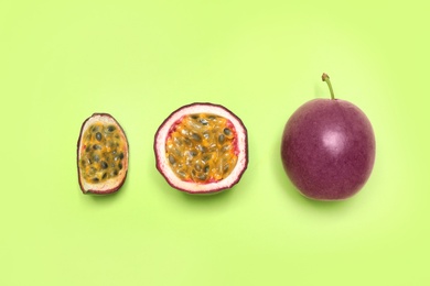 Photo of Fresh ripe passion fruits (maracuyas) on light green background, flat lay