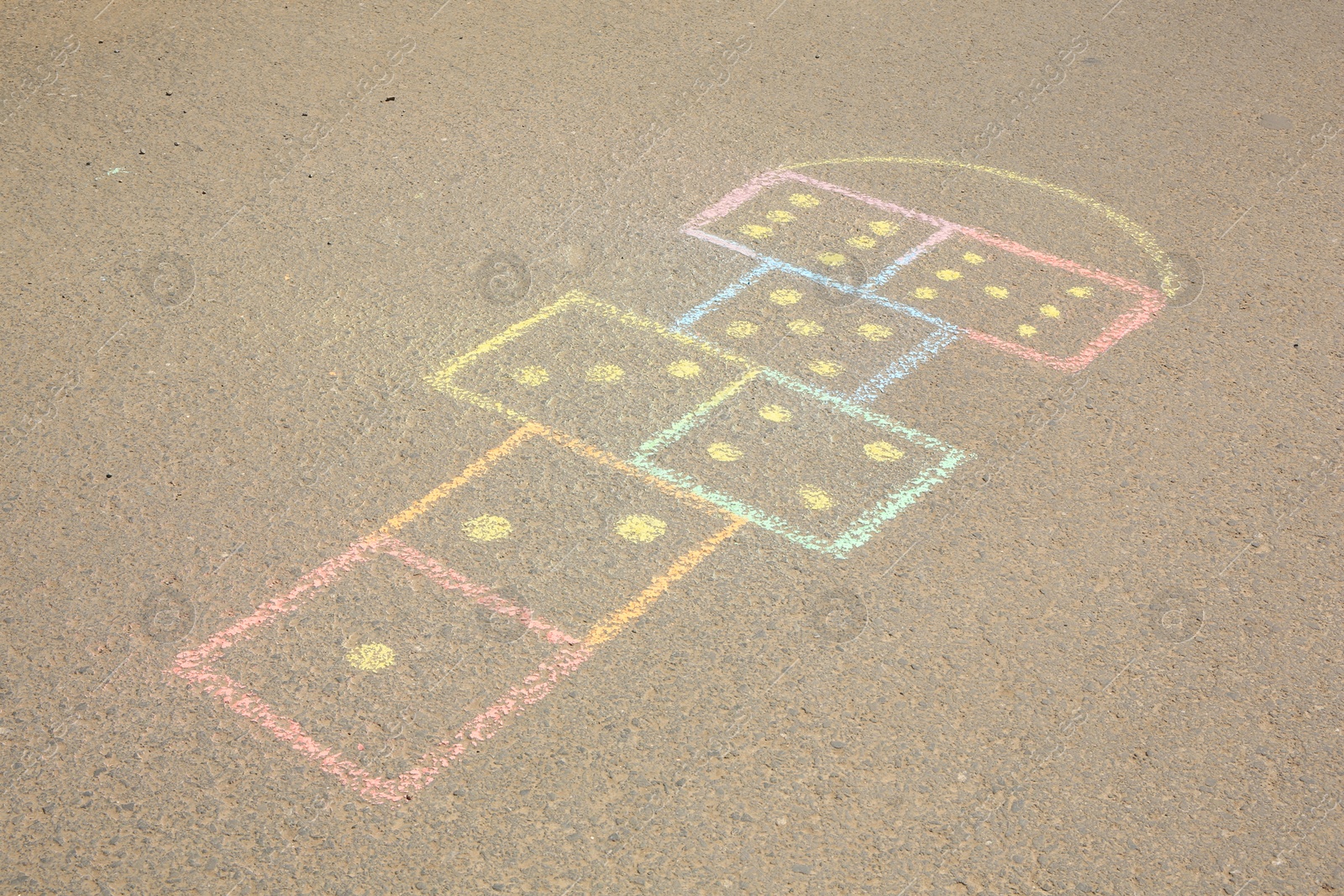 Photo of Hopscotch drawn with colorful chalk on asphalt outdoors