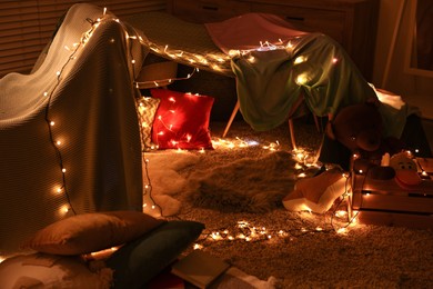Beautiful play tent decorated with festive lights at home