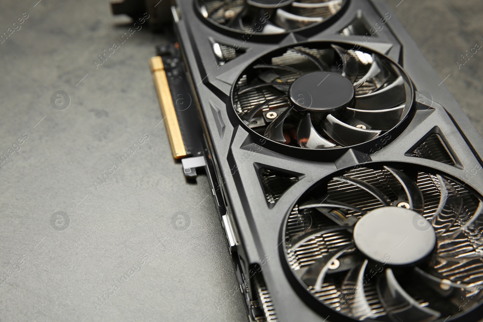 Photo of One computer graphics card on grey textured table, closeup. Space for text