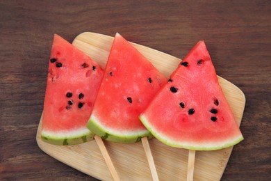 Slices of delicious ripe watermelon on wooden table, top view