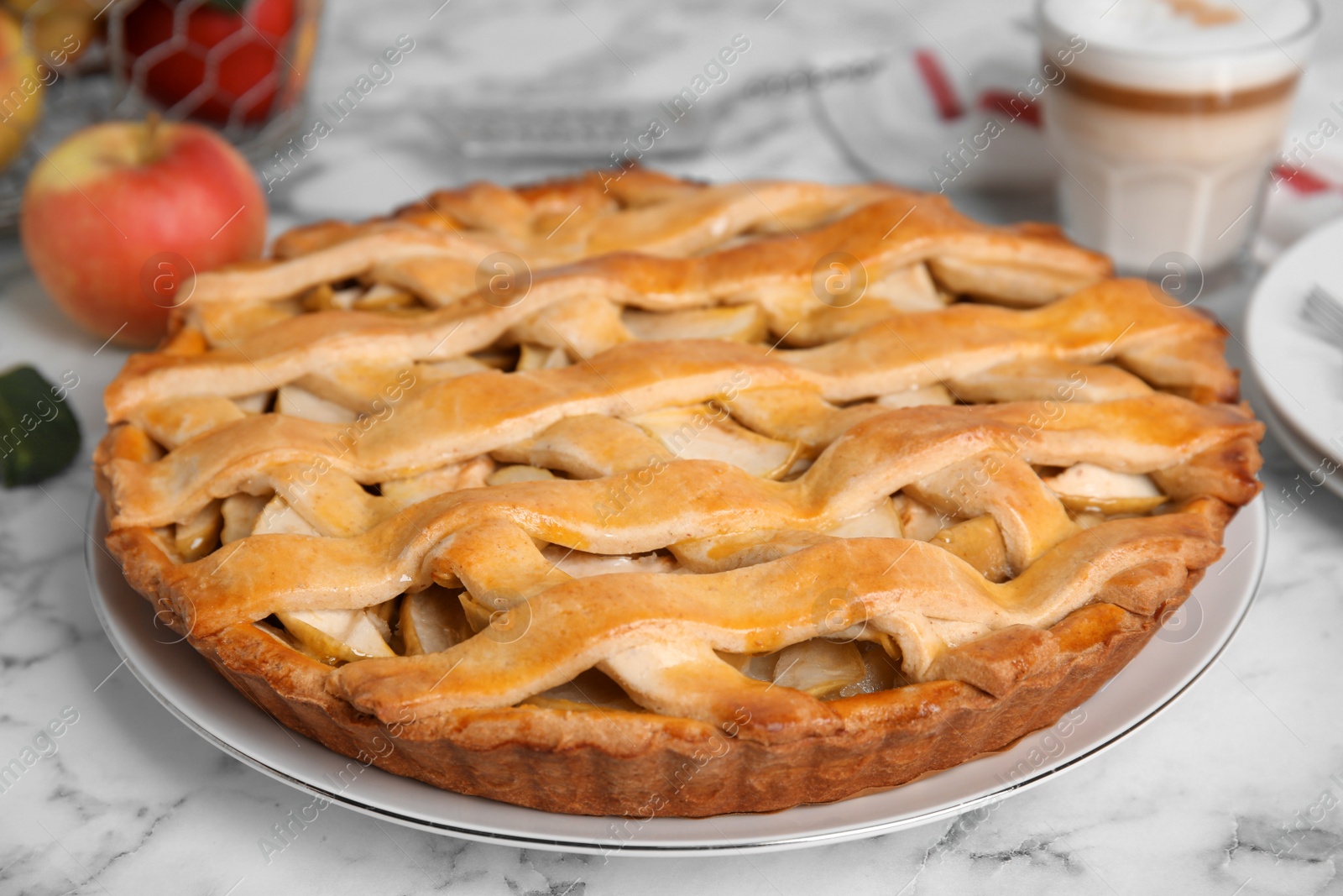 Photo of Delicious traditional apple pie on white marble table, closeup