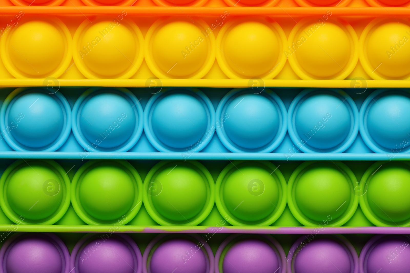 Photo of Rainbow pop it fidget toy as background, closeup