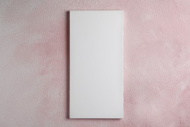 Blank canvas hanging on pink wall, space for text