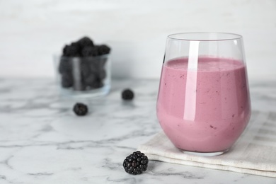 Glass with blackberry yogurt smoothie on marble table