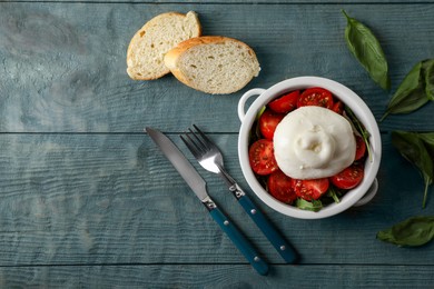 Photo of Delicious burrata cheese with tomatoes served on grey wooden table, flat lay. Space for text
