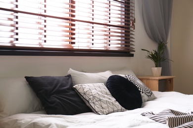 Photo of Modern room interior with comfortable double bed and window blinds