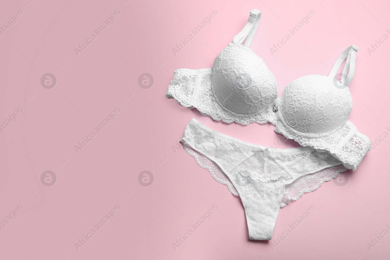 Photo of Elegant women's underwear on pink background, flat lay. Space for text