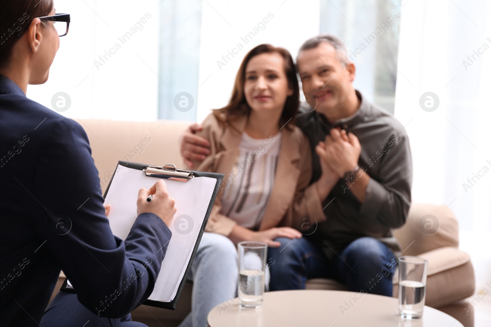 Photo of Psychotherapist and happy couple having meeting in office. Family counselling