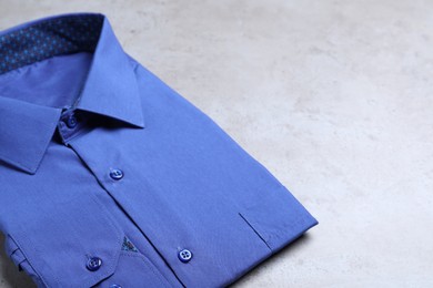 Photo of Stylish blue shirt on grey background. Dry-cleaning service