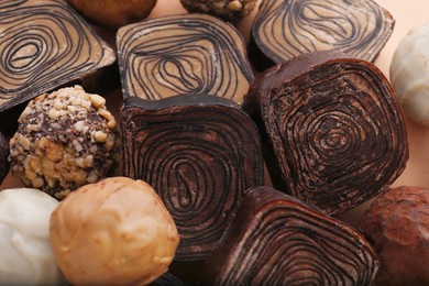 Photo of Different tasty chocolate candies as background, closeup