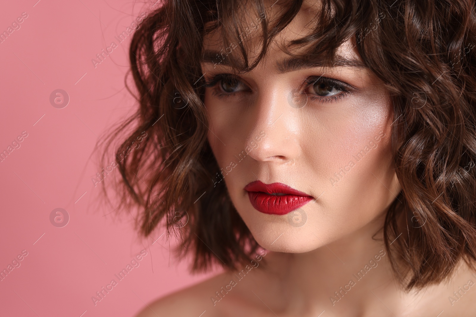 Photo of Beautiful young woman with wavy hairstyle on pink background, closeup. Space for text