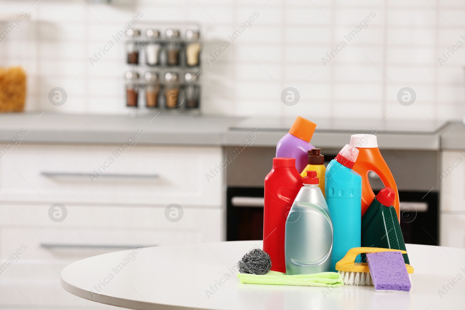 Photo of Set of cleaning supplies on table in kitchen. Space for text