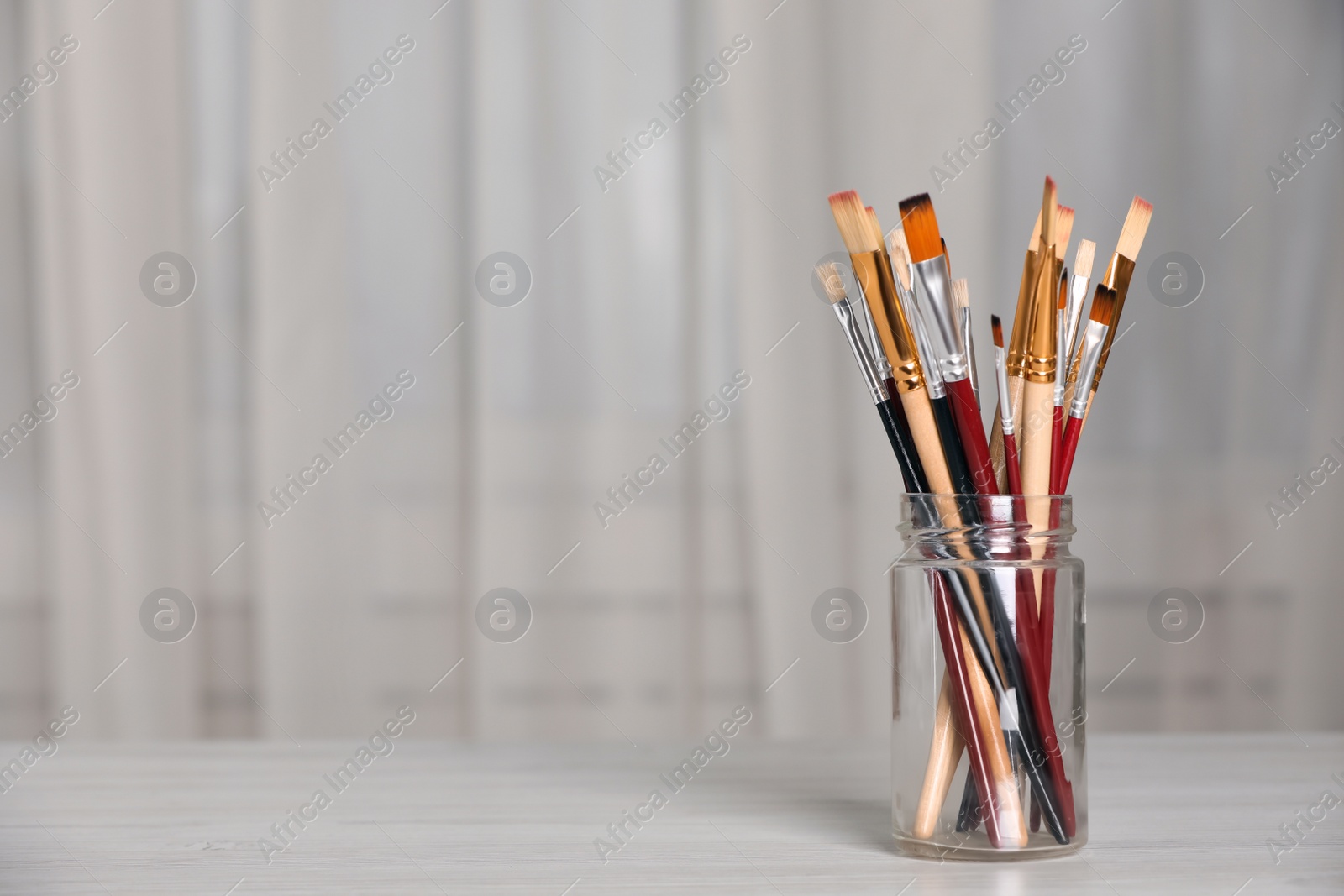 Photo of Many different paintbrushes on white wooden table indoors, space for text