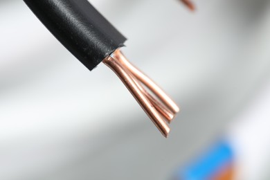 Photo of Black electrical wire on blurred background, closeup