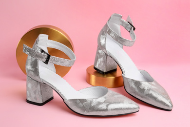 Photo of Stylish silver female shoes and decor on pink background, closeup