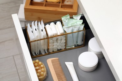 Storage of different feminine and personal care products in drawer indoors