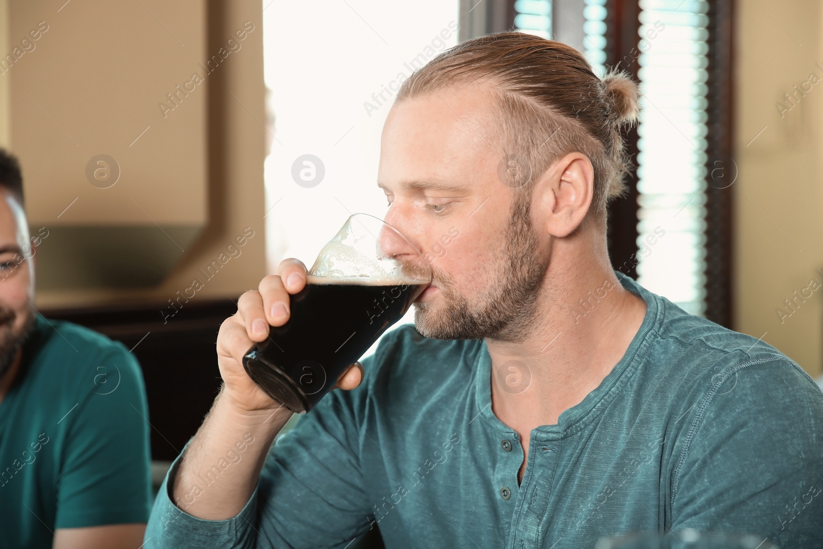 Photo of Bearded man drinking tasty beer in pub