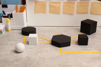 Photo of Business process scheme with geometric figures and stationery on light grey table