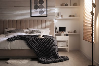 Photo of Soft chunky knit blanket on bed in stylish room interior