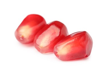 Juicy red pomegranate seeds on white background