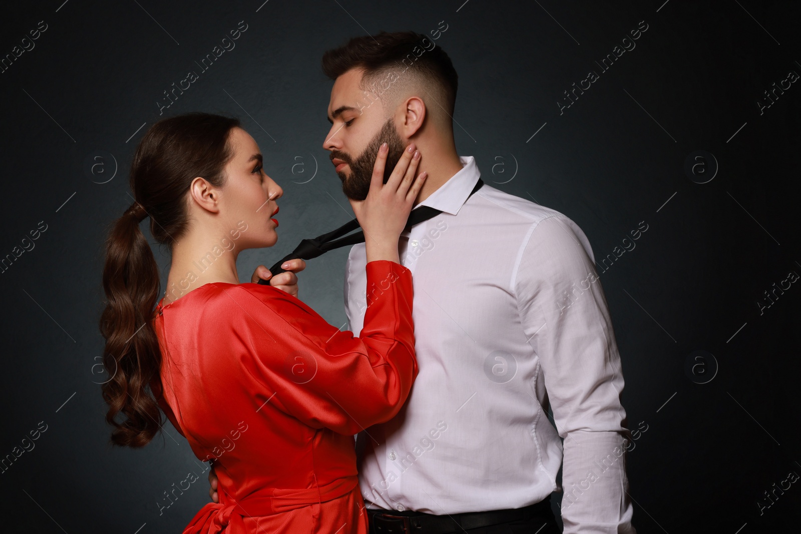 Photo of Handsome bearded man with sexy lady on dark background