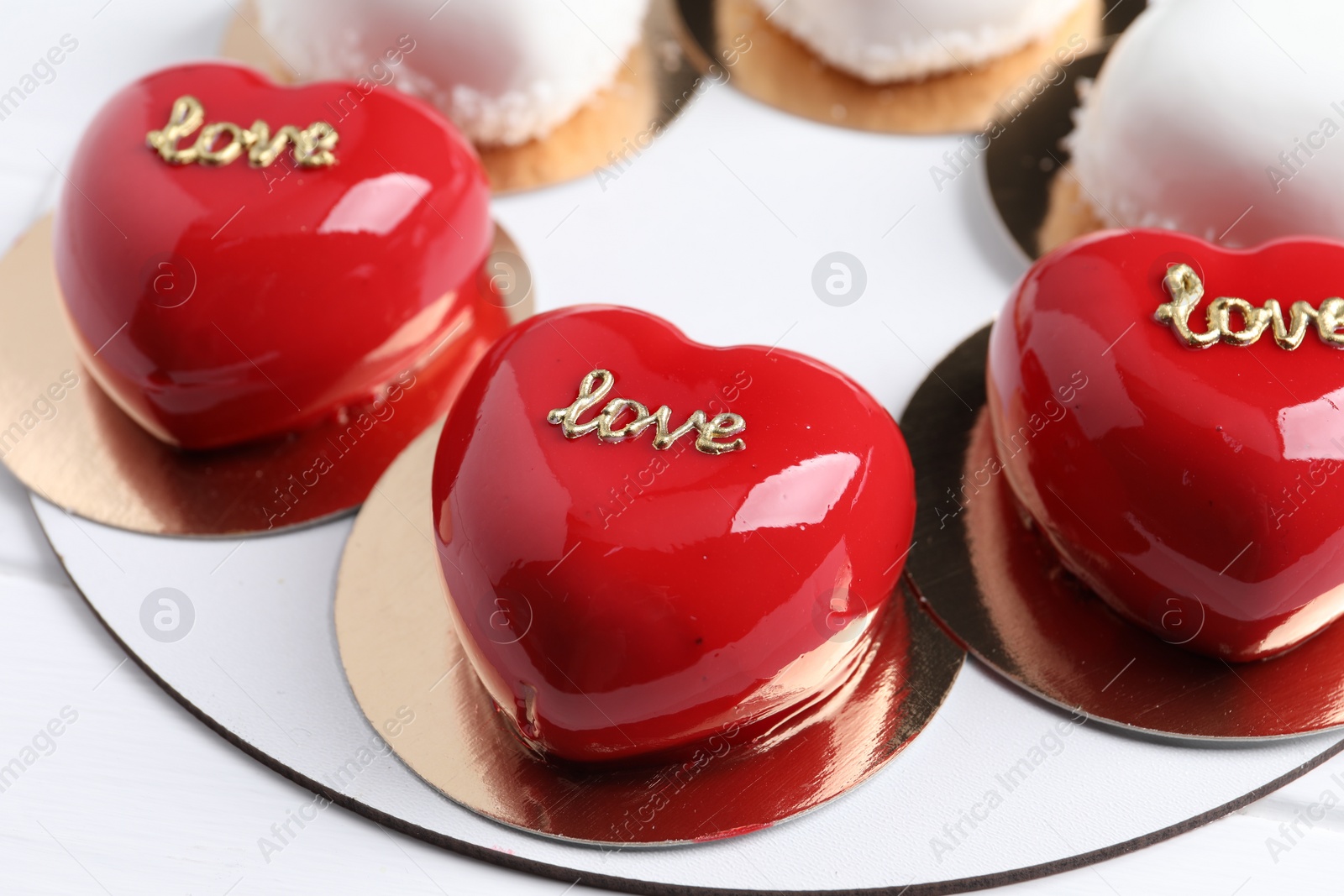Photo of St. Valentine's Day. Delicious heart shaped cakes on white wooden table, closeup