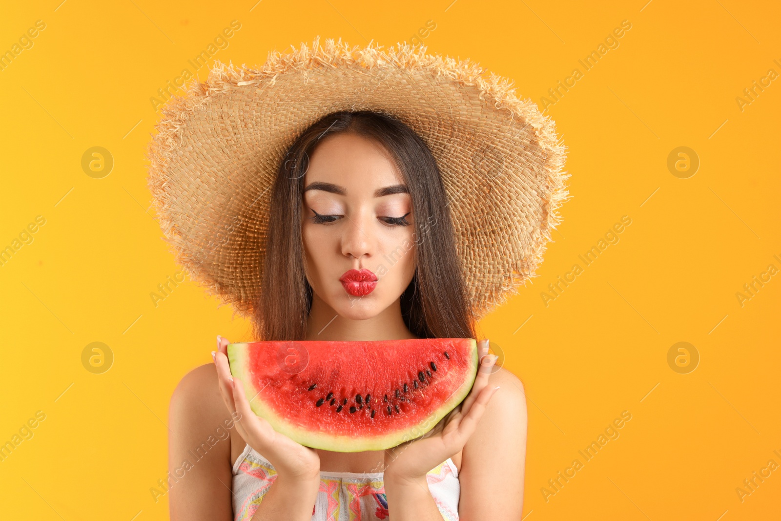 Photo of Beautiful young woman posing with watermelon on color background