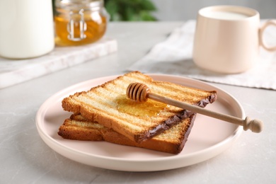 Photo of Tasty toasts with honey served on light table