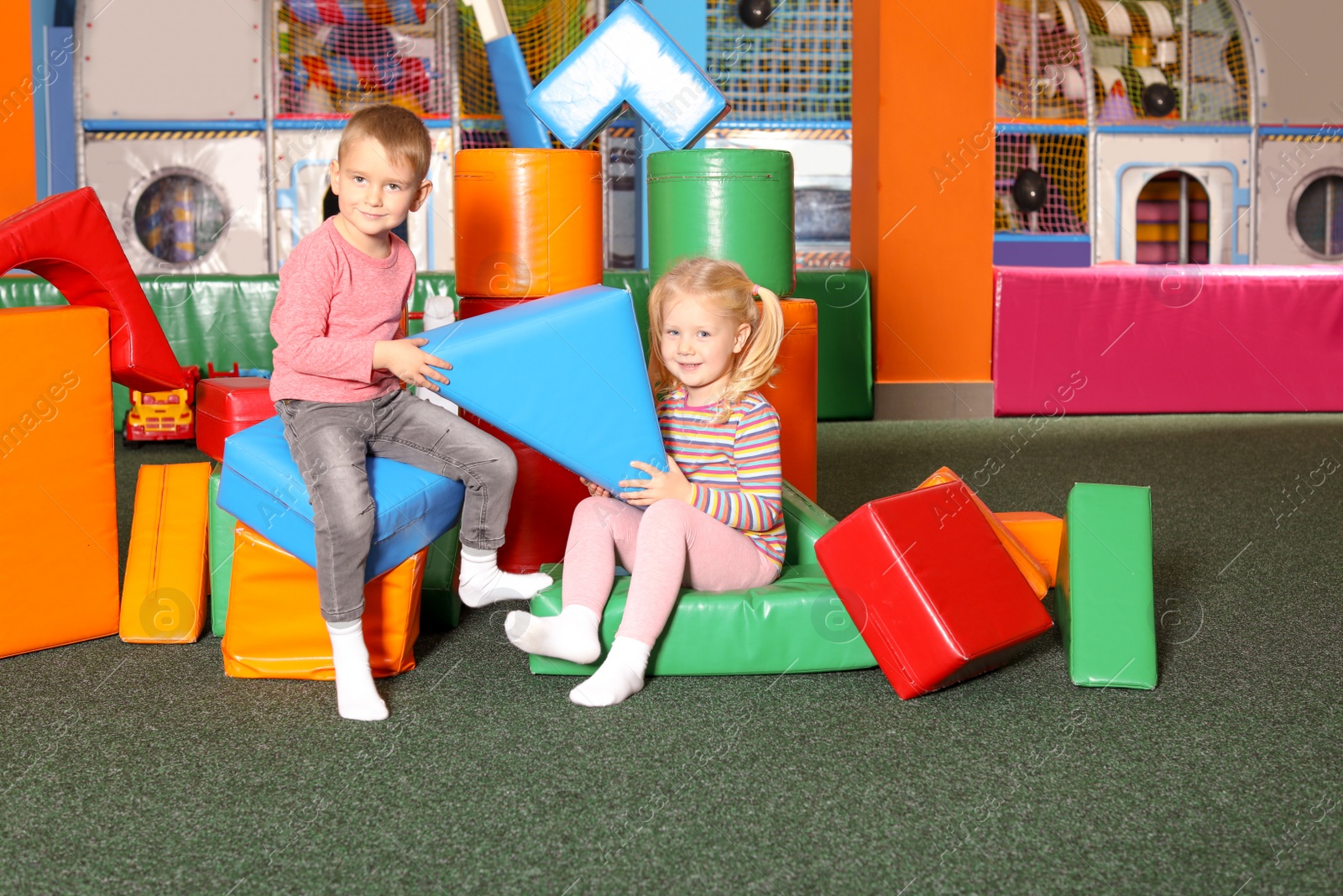 Photo of Cute children playing with colorful building blocks indoors