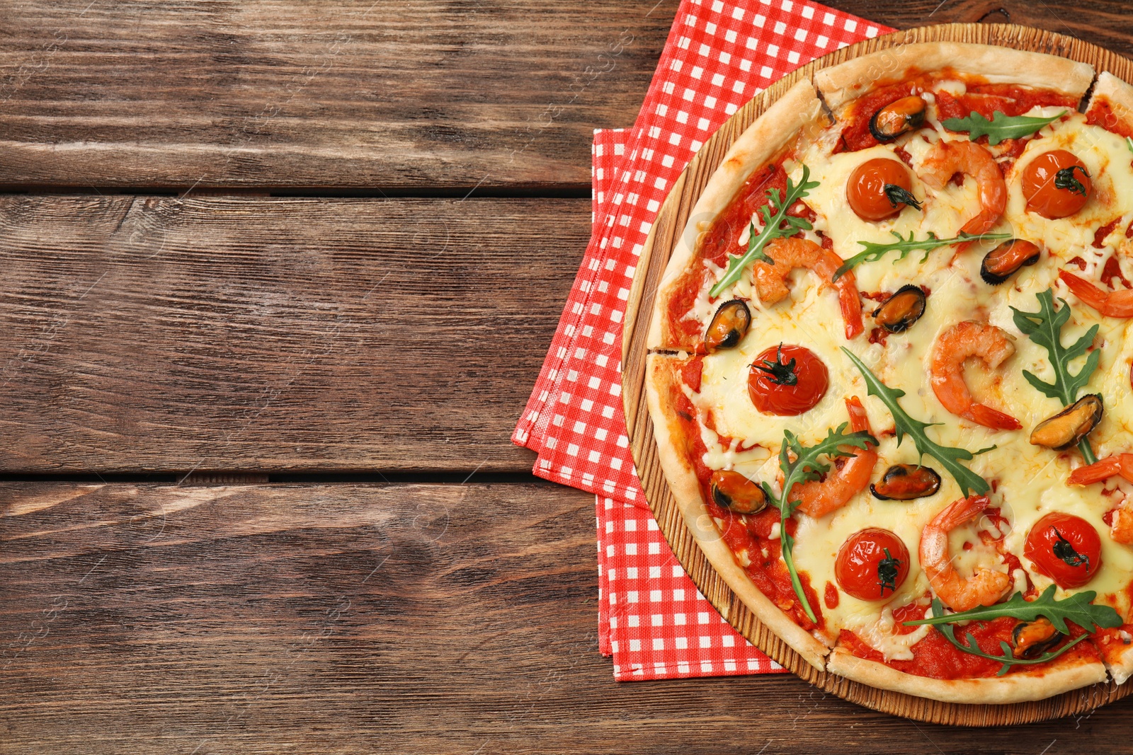 Photo of Delicious seafood pizza on wooden table, top view. Space for text