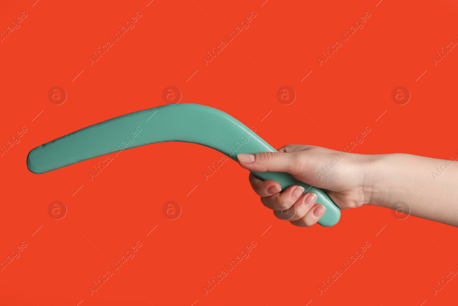 Photo of Woman holding boomerang on red background, closeup