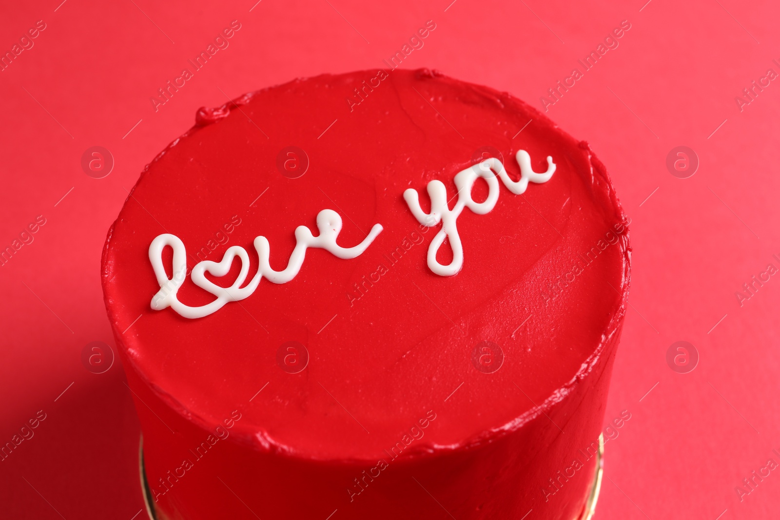 Photo of Bento cake with text Love You on red table, closeup. St. Valentine's day surprise