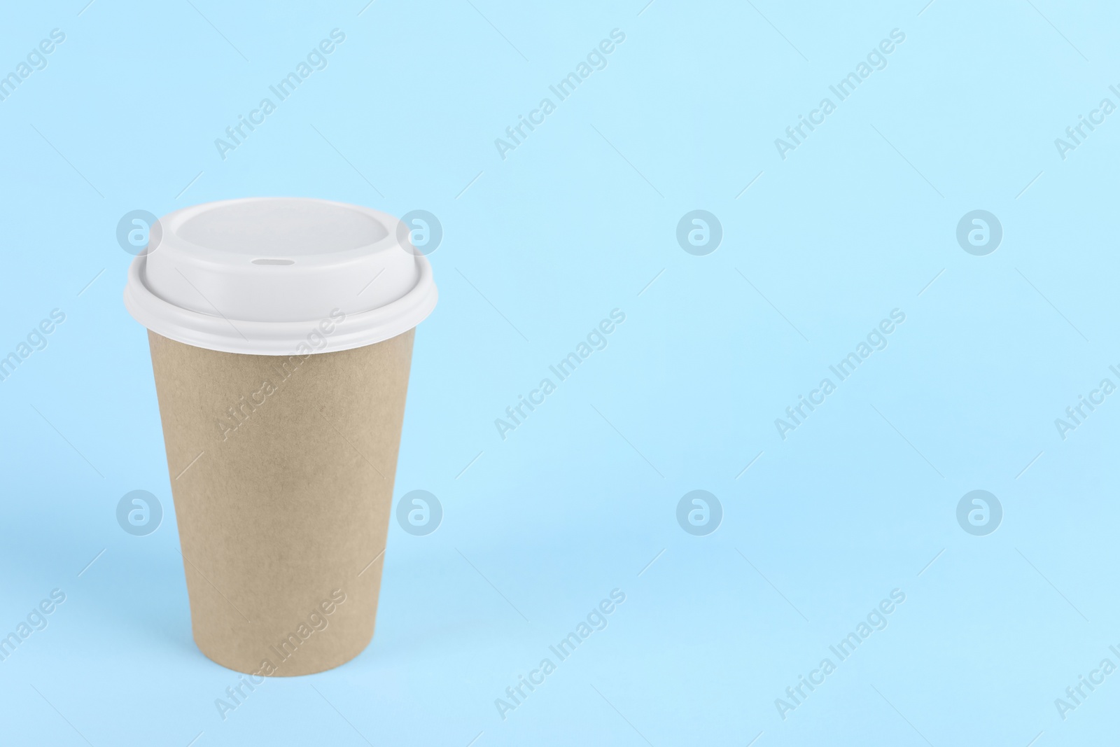 Photo of Paper cup with plastic lid on light blue background, space for text. Coffee to go