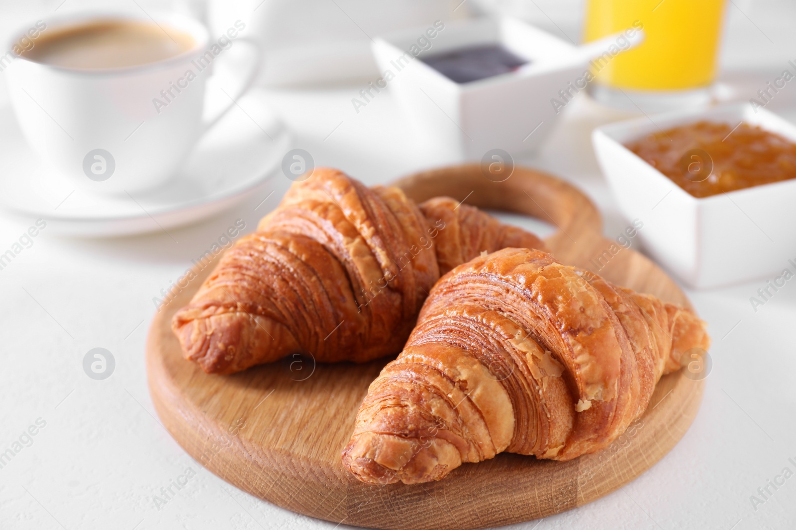 Photo of Fresh croissants on white table. Tasty breakfast