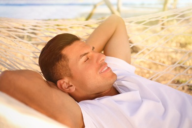 Man relaxing in hammock outdoors on sunny day. Summer vacation