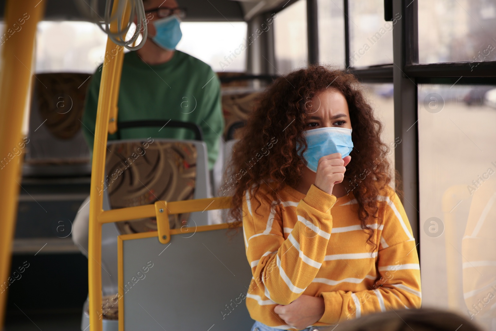 Photo of African-American woman with disposable mask on bus. Virus protection