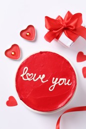 Photo of Bento cake with text Love You, candles, gift box and paper hearts on white table, flat lay. St. Valentine's day surprise