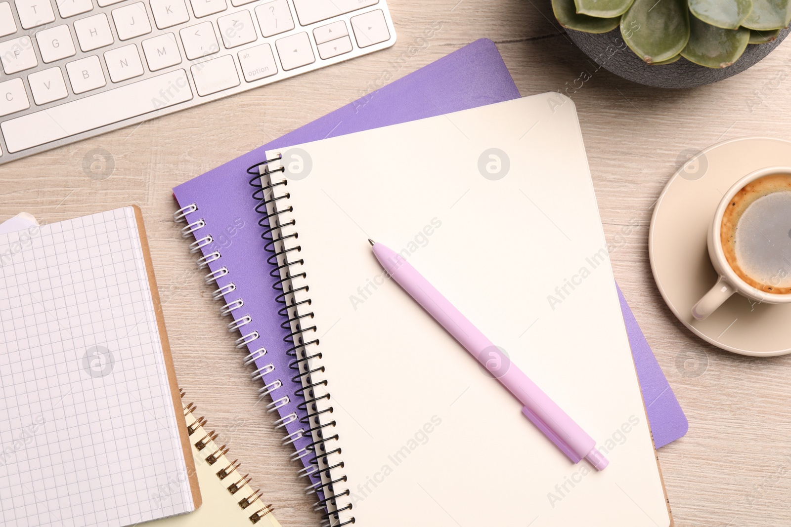 Photo of Flat lay composition with spiral notebooks, coffee and pen on wooden table