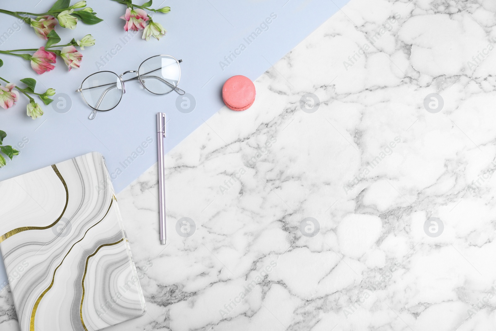 Photo of Flat lay composition with notebook, glasses and macaron on marble table, space for text