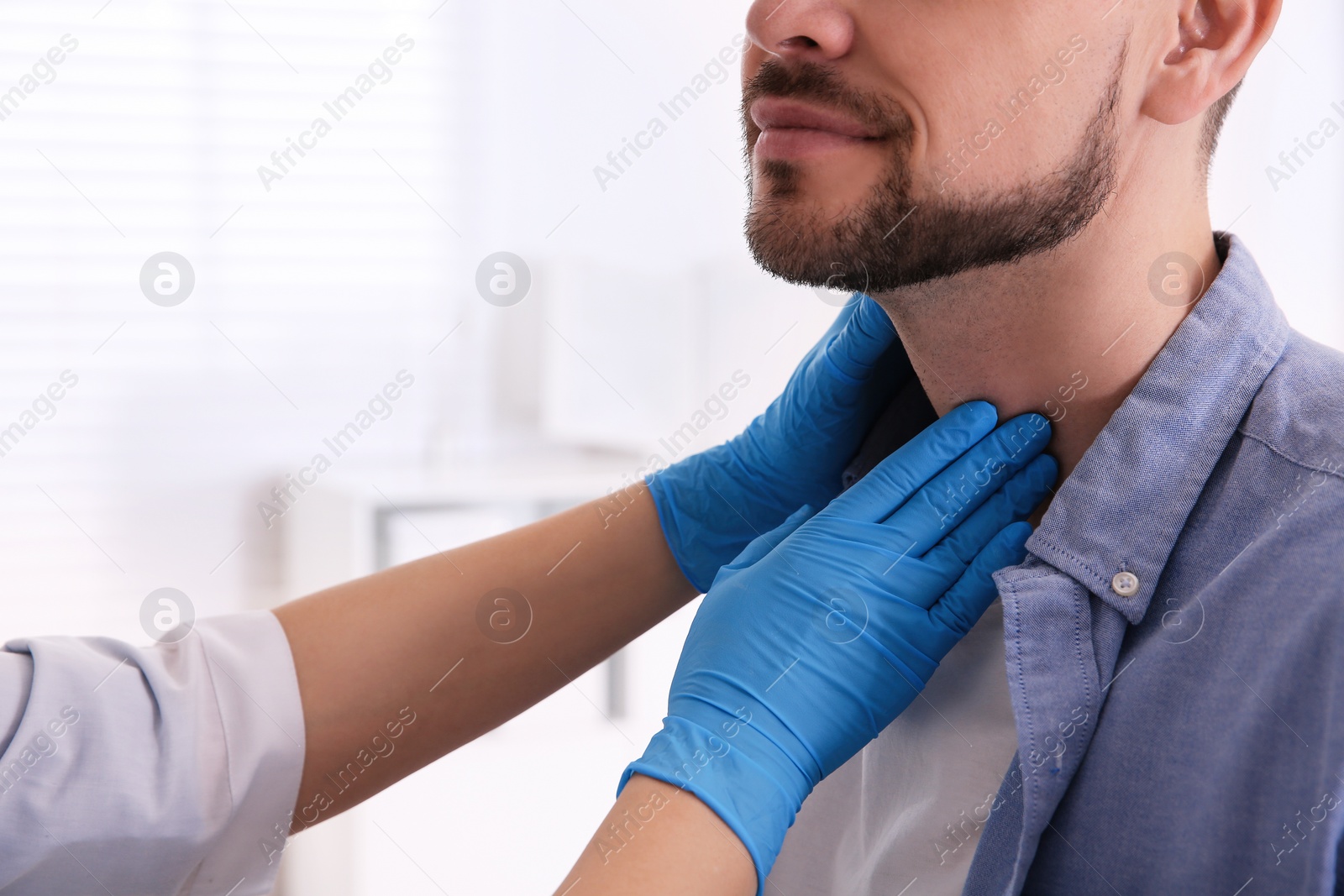 Photo of Doctor examining thyroid gland of patient in hospital, closeup